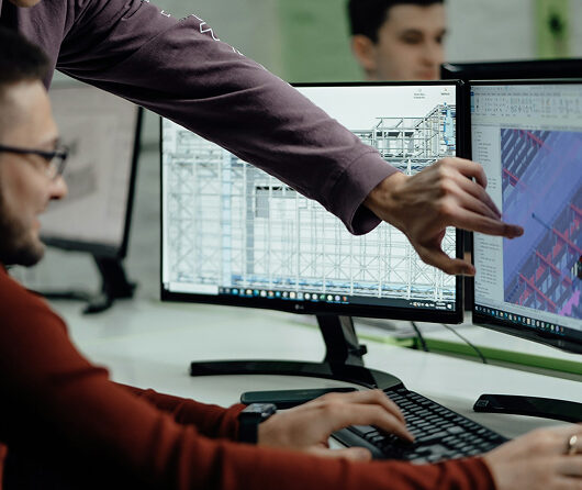 cleanroom experts at a desk looking at a screen