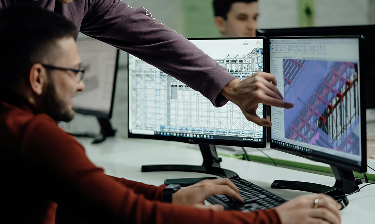 cleanroom experts at a desk looking at a screen
